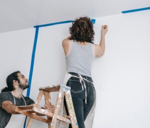 Home owners trying to paint a wall